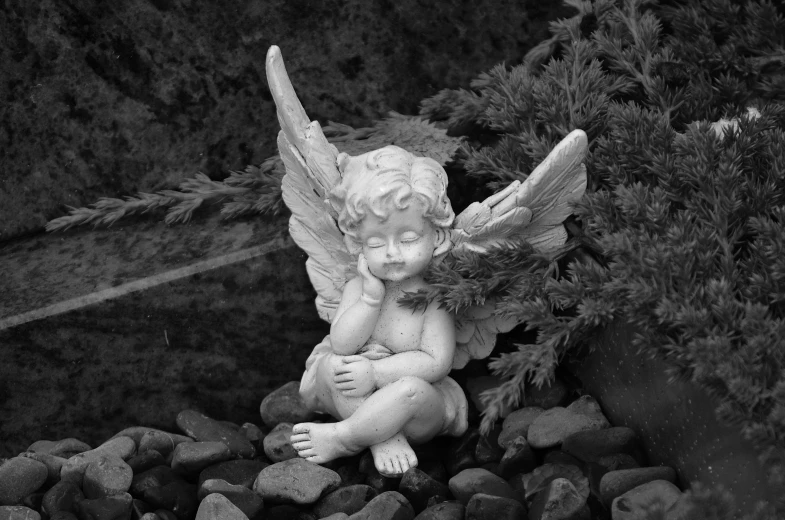a black and white photo of a statue of an angel, a statue, fairy garden, lying pose on stones, precious moments, high quality product image”
