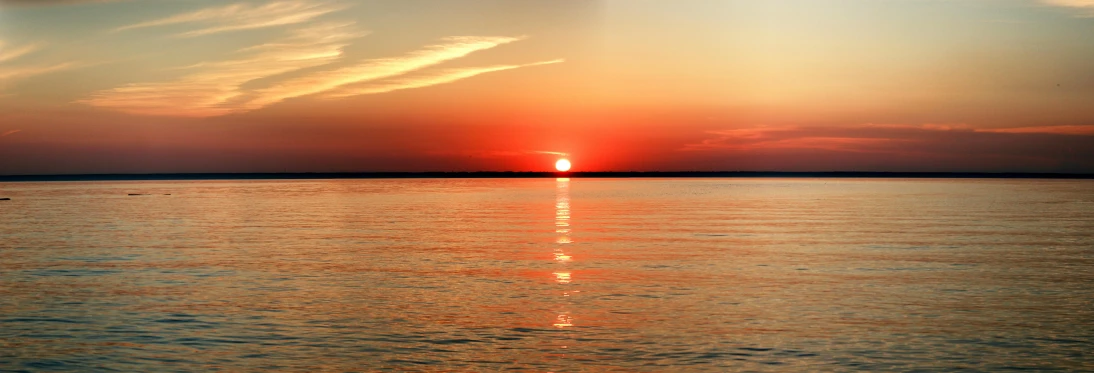 the sun is setting over a body of water, red horizon, photo taken with provia, sunset panorama, fan favorite
