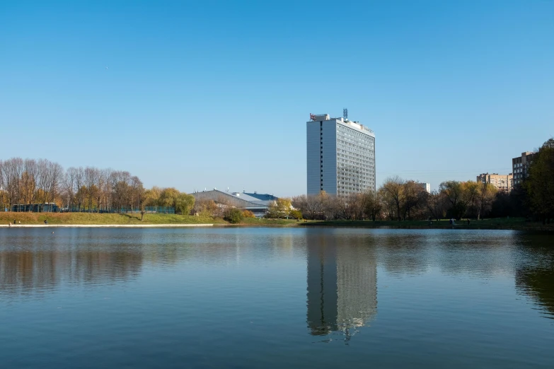 a pond in front of a tall white building