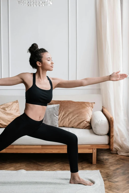 woman in yoga outfit, standing with her hands outstretched wide open on one end