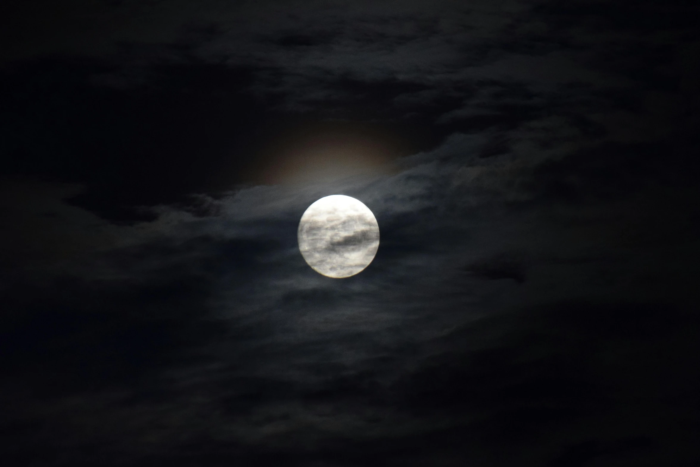 the moon is partially obscured by a black cloud