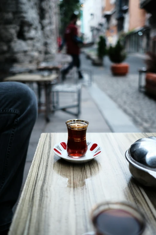 a person sitting at a table with a cup of tea, by irakli nadar, hurufiyya, istanbul, 4k photo”