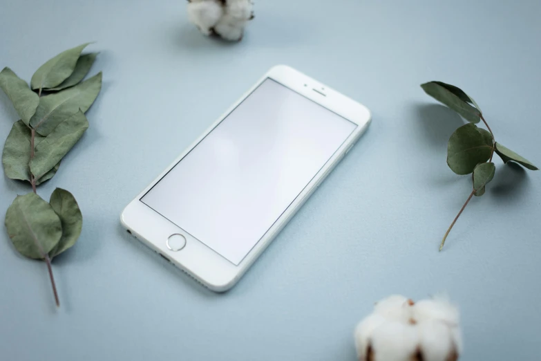 a white cell phone sitting on top of a table, trending on pexels, lots of white cotton, white and pale blue, apple design, avatar image