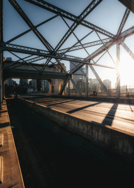 the sun shines through the beams of a bridge, inspired by Elsa Bleda, vancouver, 8k 28mm cinematic photo, 120 degree view, image