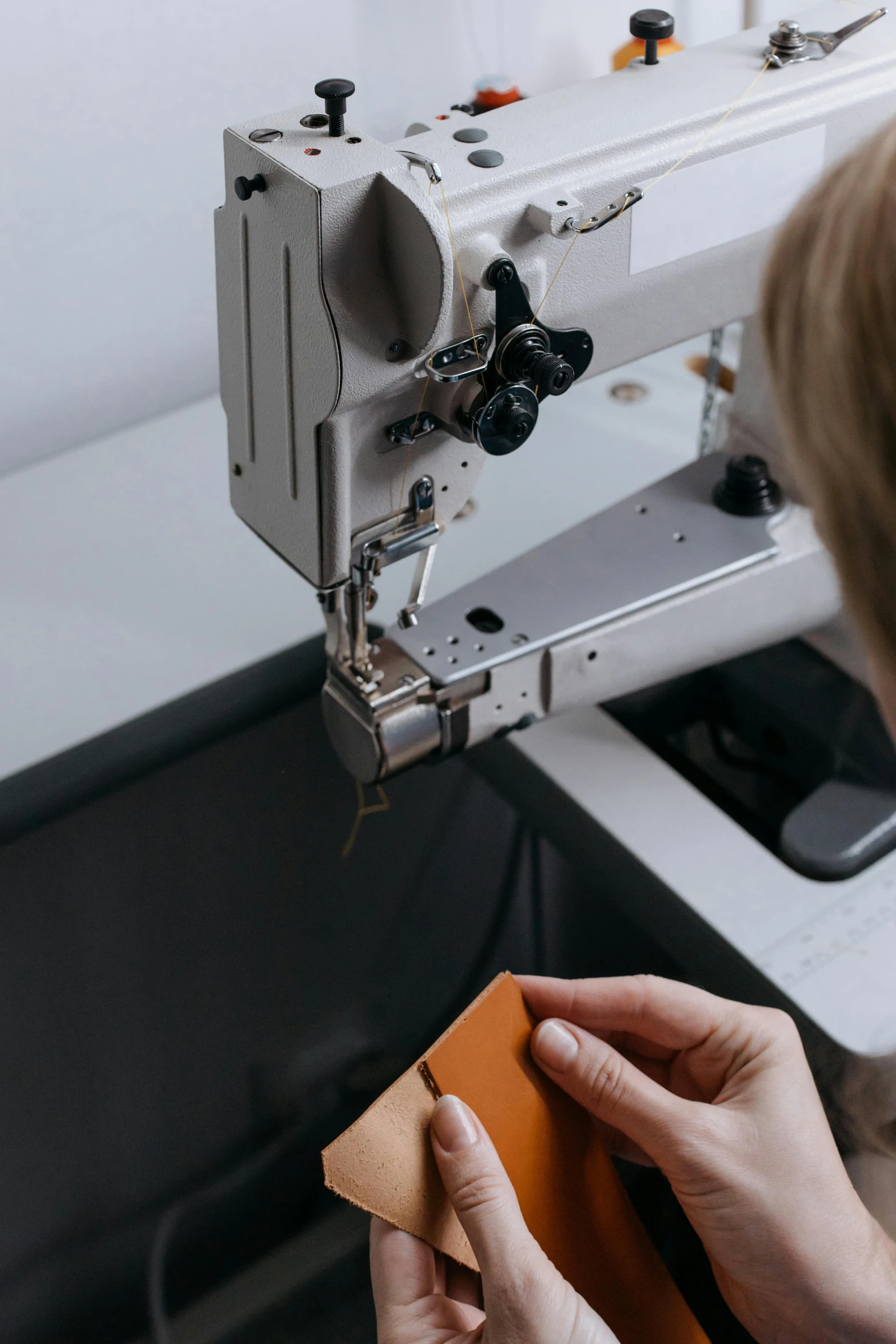 the woman is sewing and pressing things on her own hand