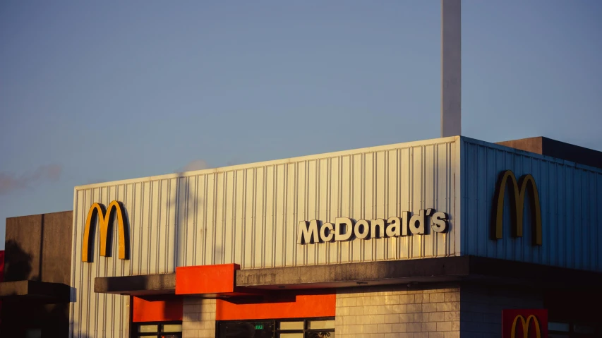 a mcdonald's restaurant with a clock tower in the background, a portrait, unsplash, modernism, medium format. soft light, simple brutalist architecture, golden hour photo, leaked photo