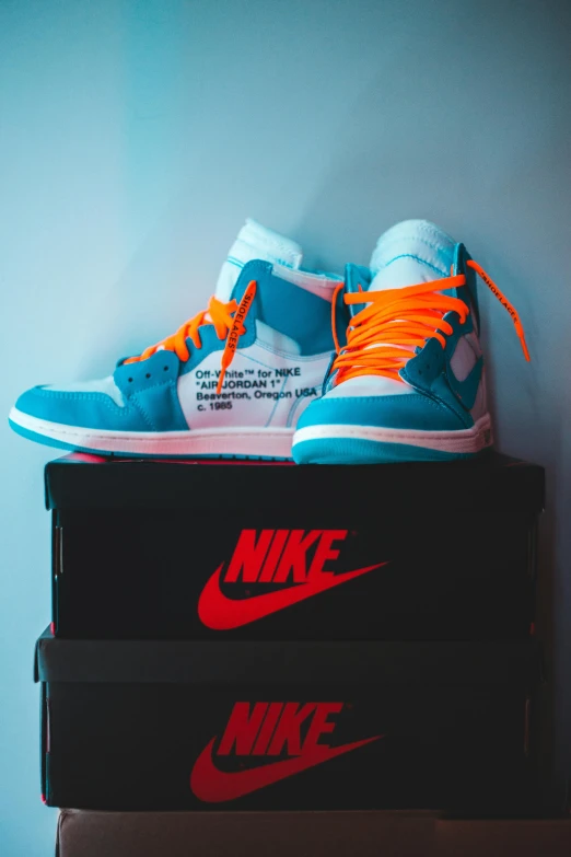 a pair of sneakers sitting on top of a box, unsplash contest winner, graffiti, blue!! with orange details, wearing off - white style, jordan, laces and ribbons