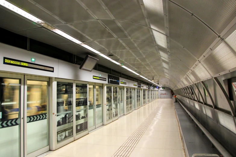 a train moving on the track through an enclosed platform