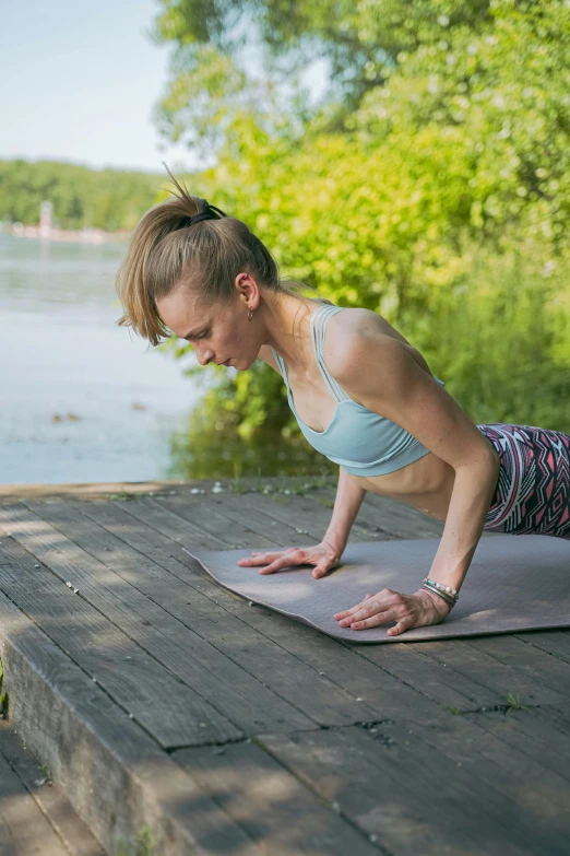 a woman doing push ups on a yoga mat, by Grytė Pintukaitė, lake view, square, high quality picture, cardboard