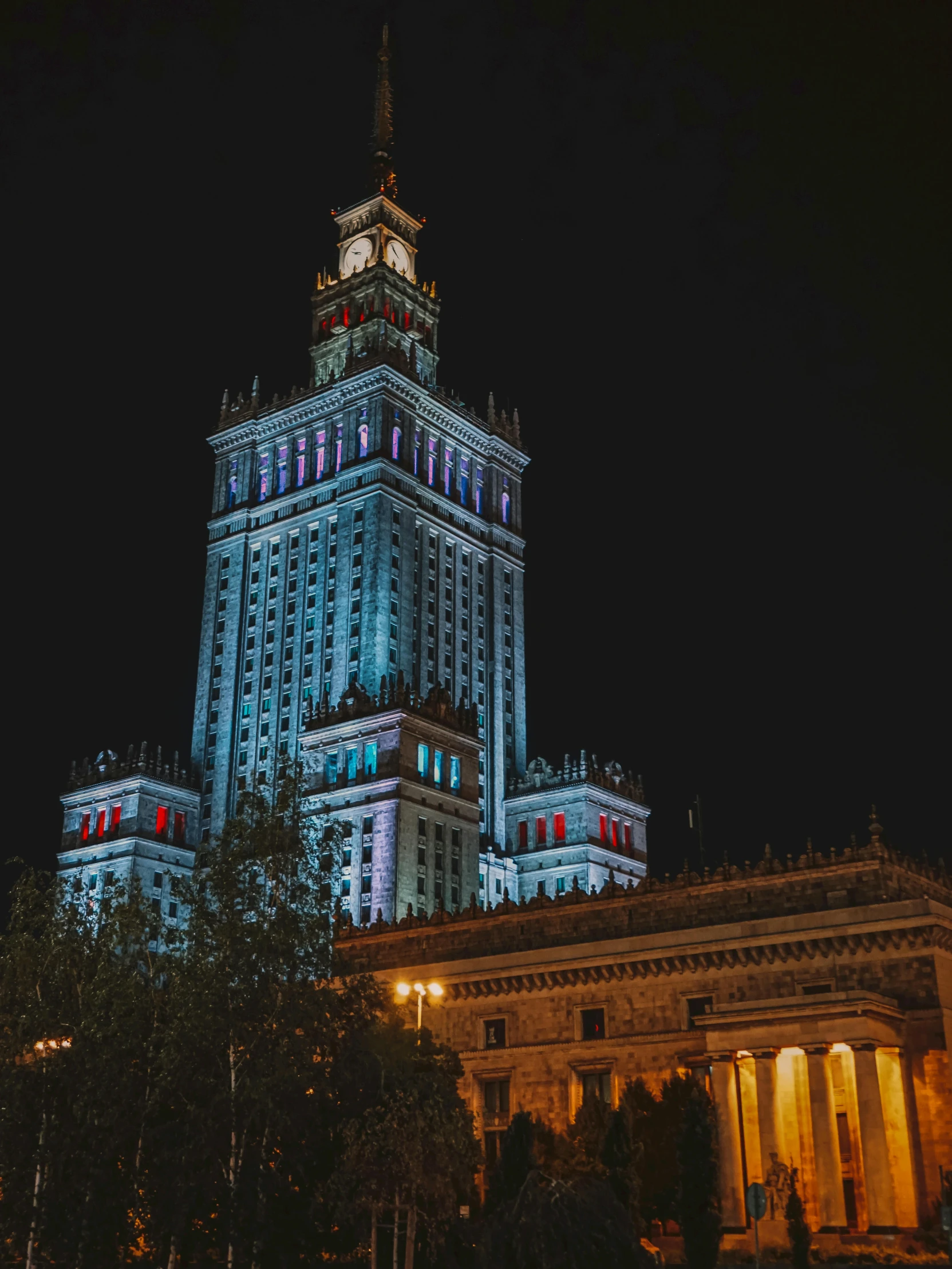 an illuminated clock tower atop the white building