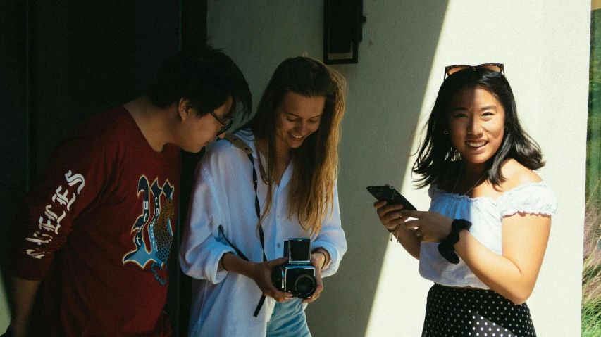 a group of young people standing next to each other, a picture, pexels contest winner, happening, checking her phone, avatar image, three, coloured film photography