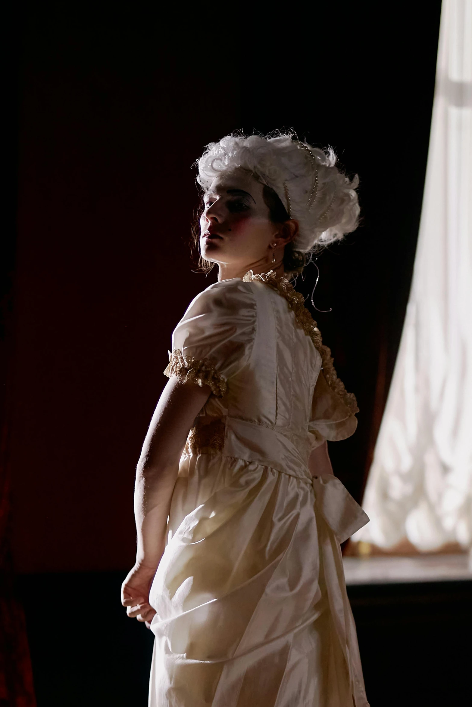 a woman in a dress and white hair is wearing a large white hat