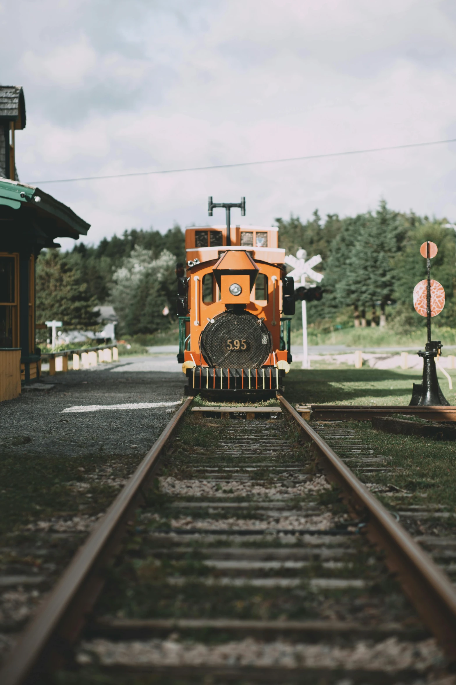 a train traveling down train tracks next to a train station, a colorized photo, by Jessie Algie, unsplash, british columbia, 🚿🗝📝, a wooden, crying engine