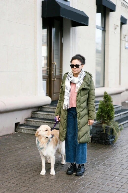 a woman walking a dog down a sidewalk, by Zofia Stryjenska, ootd, russian, olive green, extra wide