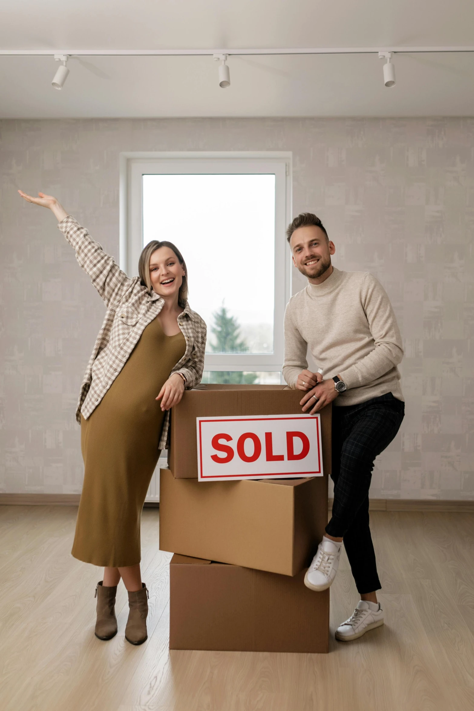 a man and woman standing next to a box with a sold sign on it, a colorized photo, pexels contest winner, excited, square, at home, developers