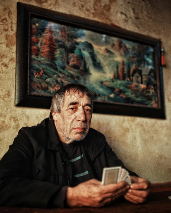 a man sitting at a table holding a cell phone, a polaroid photo, by Géza Dósa, pexels contest winner, hyperrealism, a multidimensional cozy tavern, an elderly, maxim sukharev, lgbtq