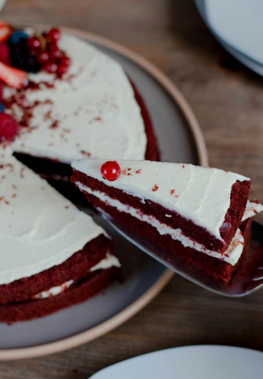 a red velvet cake with a slice taken out of it, by Julia Pishtar, hurufiyya, high quality product image”, wide angle”, may)