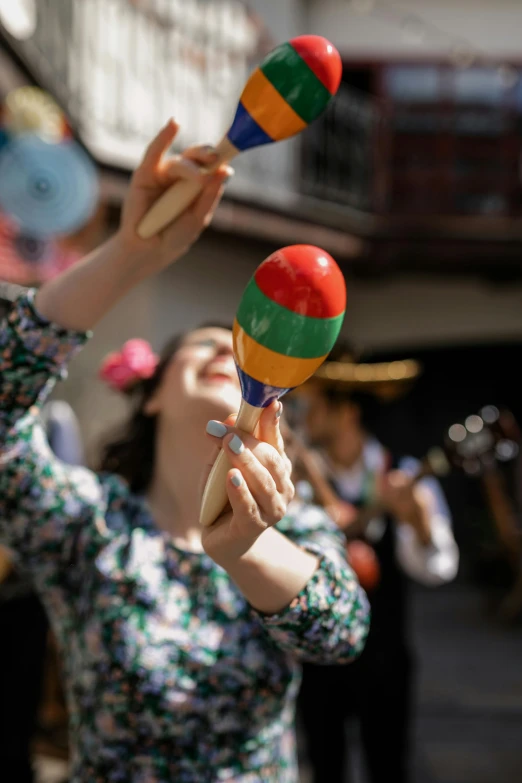 a woman holding two small colorful balls