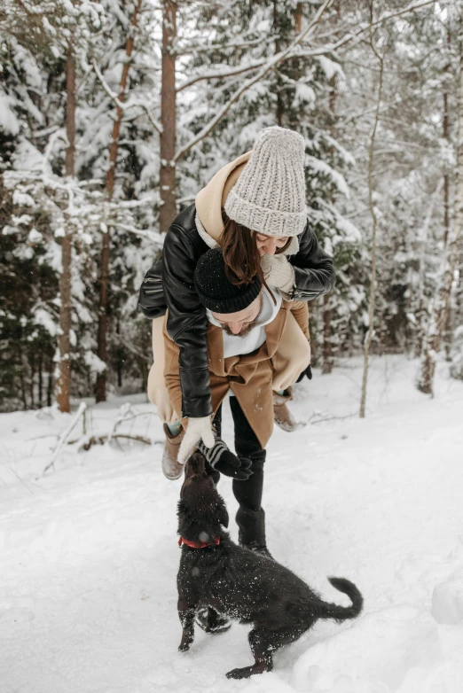 woman holding a young child, while a dog looks at her