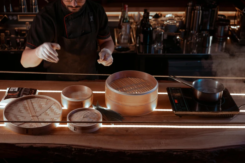 a man that is standing in front of a counter, by Julia Pishtar, pexels contest winner, dumplings on a plate, neon glowing wood, server in the middle, churning