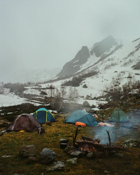 a group of tents sitting on top of a snow covered mountain, by Jessie Algie, pexels contest winner, rainy outside, lots of fire, stålenhag, 2 0 0 0's photo