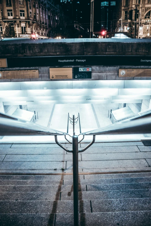 a bus stop on a city street at night, inspired by Andreas Gursky, pexels contest winner, light and space, stairway, front symetrical, central station in sydney, stainless steal