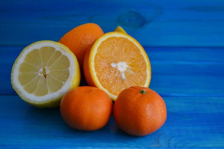 a group of oranges sitting on top of a blue table, on a wooden table