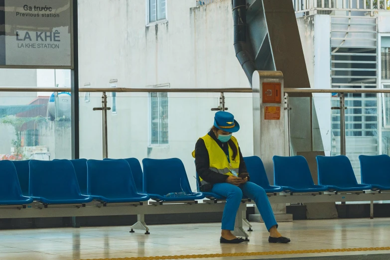 a person sitting on some benches in an airport