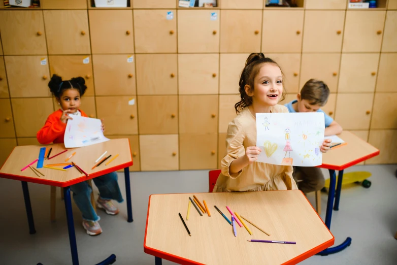 a group of children sitting at desks in a classroom, a child's drawing, pexels contest winner, danube school, girl creates something great, ayne haag, having a great time, trending arstationhq