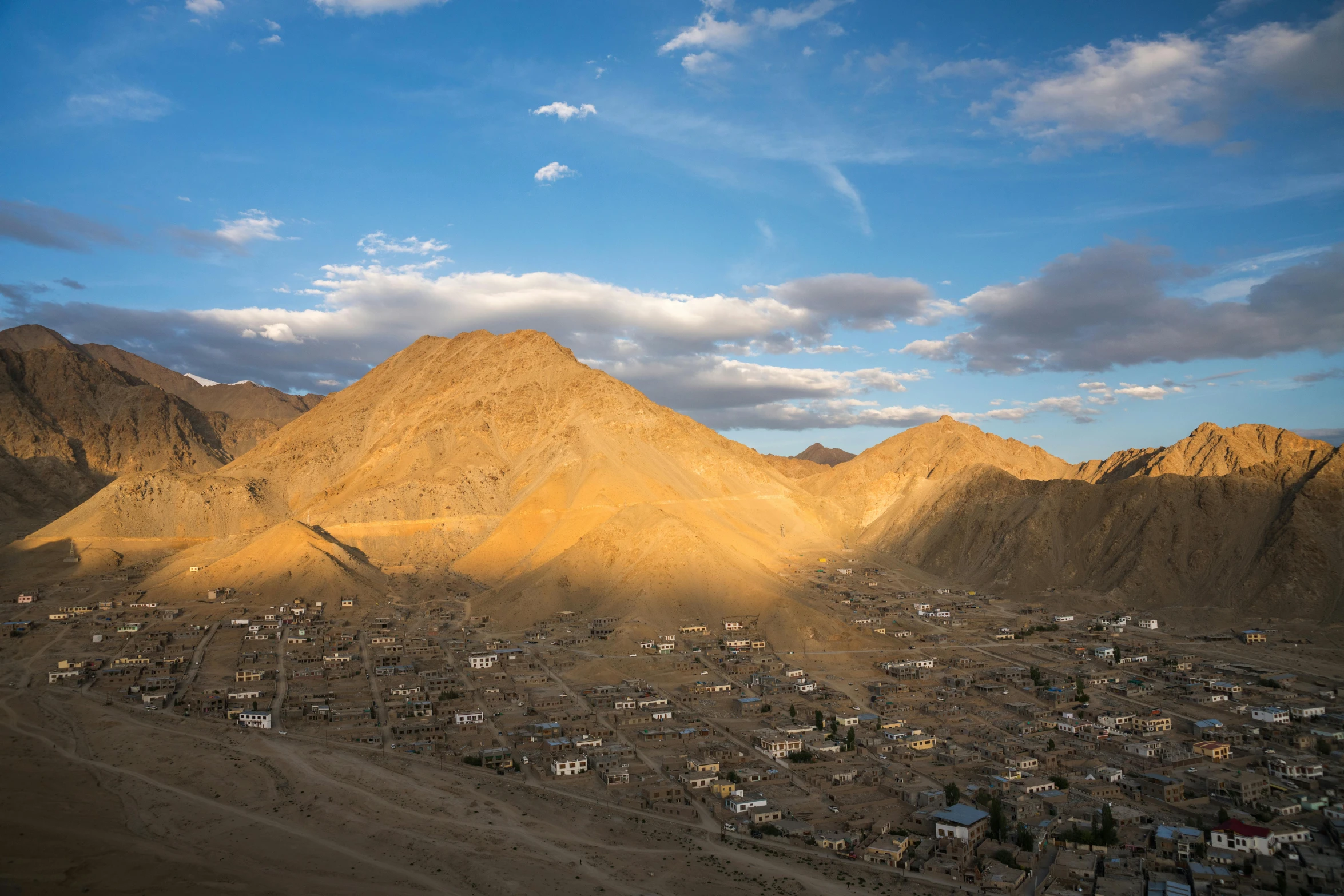 a mountain with houses and mountains in the background