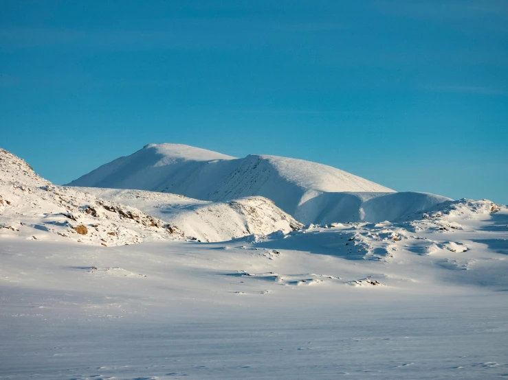 the mountains are covered in snow while the snow begins to clear