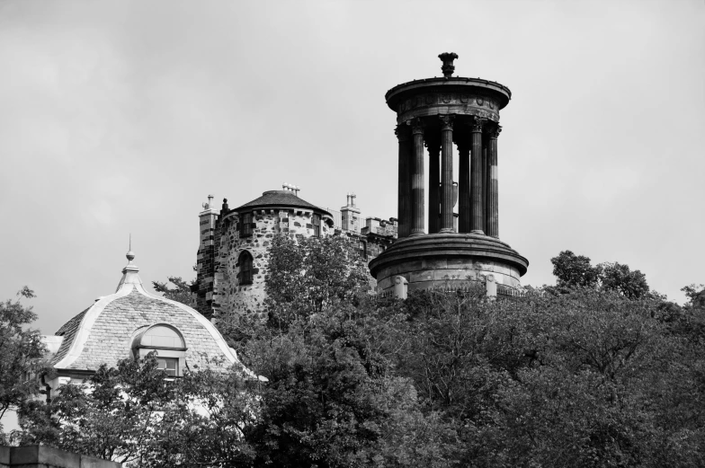 a black and white photo of a clock tower, by John Murdoch, pexels contest winner, art nouveau, palace on top of the hill, necropolis, covered with vegetation, scottish