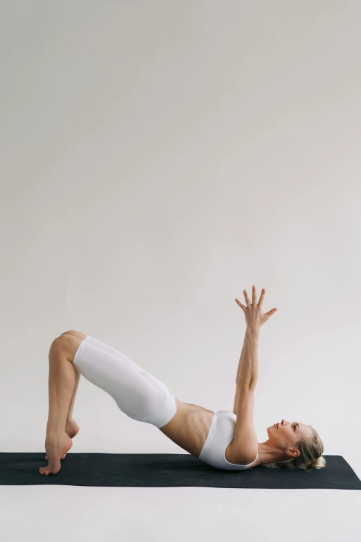 the woman is doing h ups on her yoga mat