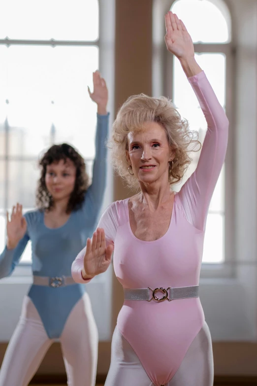 two older women wearing bodysuits dancing and smiling