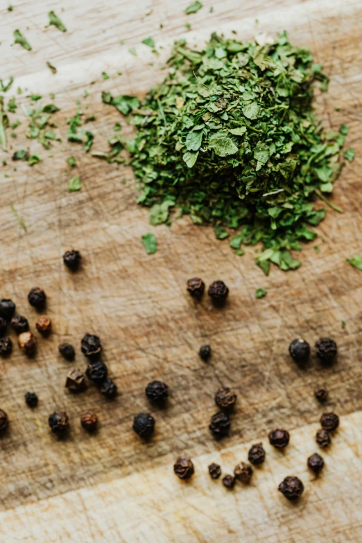 a bunch of herbs sitting on top of a wooden cutting board, trending on pexels, renaissance, pepper, half image, slightly pixelated, food particles