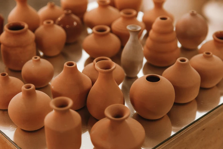 a group of clay vases sitting on top of a table, a picture, trending on pexels, they are all laying down, bulbous, thumbnail
