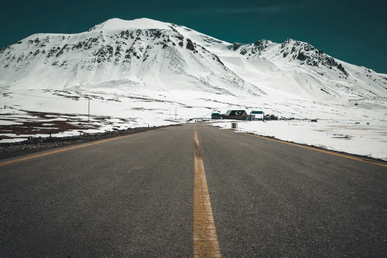 a truck sits parked at the center of a long road