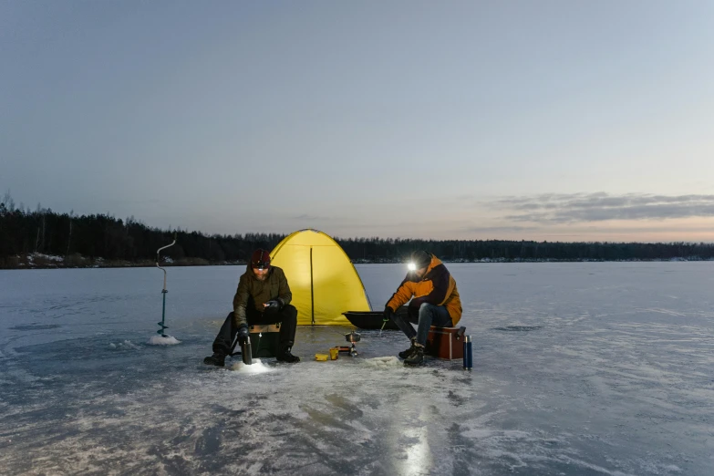 a couple of people that are sitting in the snow, a picture, by Eero Järnefelt, pexels contest winner, hurufiyya, fishing, tent, with a bright yellow aureola, laser beam ; outdoor