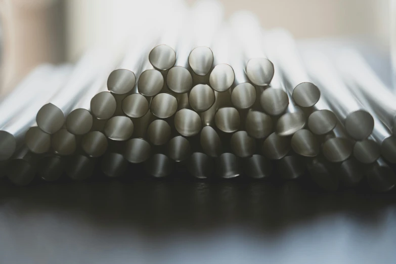 a pile of metal tubes sitting on top of a table, unsplash, process art, silver，ivory, cane, profile image, sugar