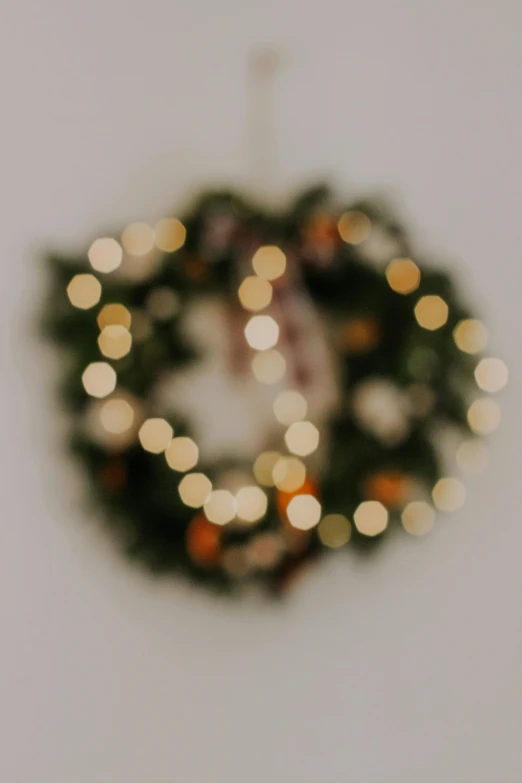 close up of a green christmas wreath and its reflection on the wall