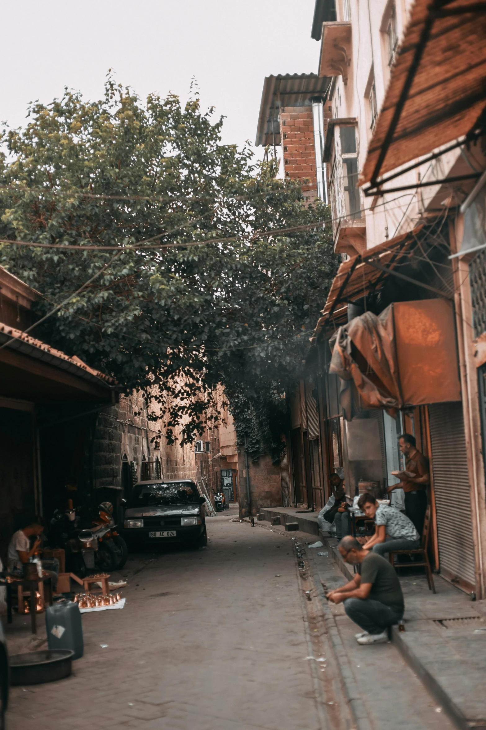 some people sitting outside a shop on a street corner