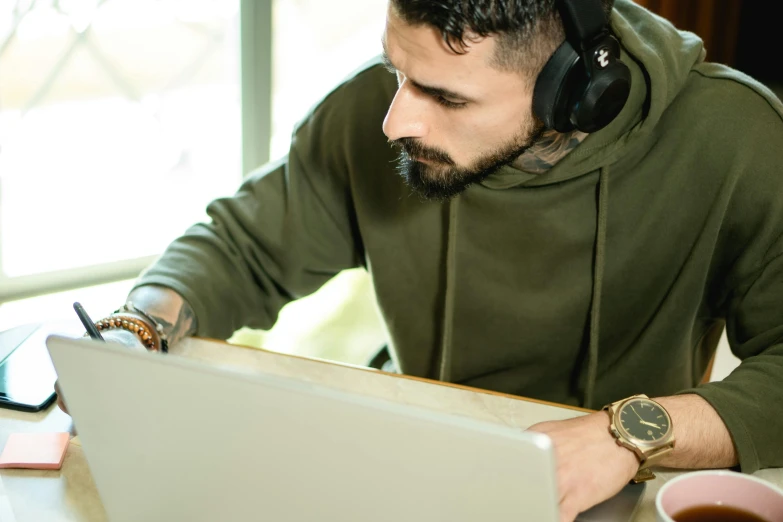 a man sitting in front of a laptop wearing headphones, trending on pexels, vinny vinesauce, casually dressed, concentration, 9 9 designs