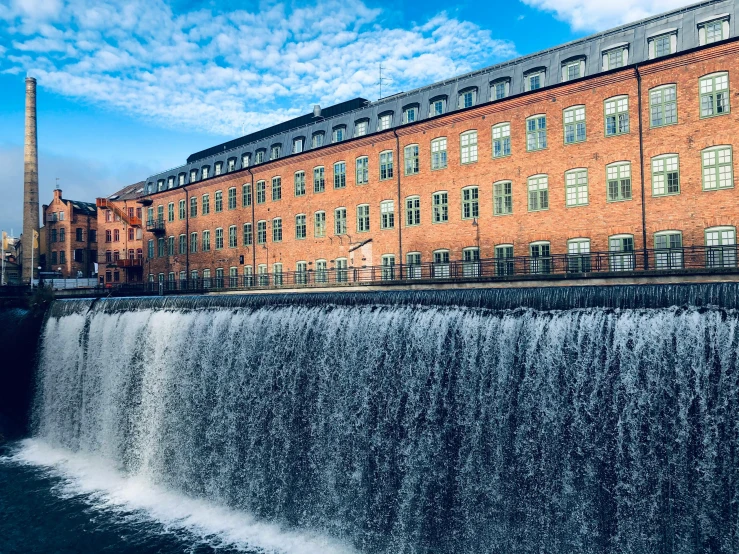 a waterfall in front of a large brick building, by Christen Dalsgaard, pexels contest winner, hurufiyya, espoo, thumbnail, mill, extremly high quality