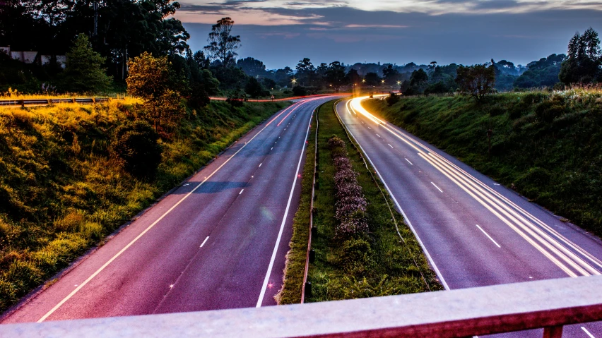 a view of a highway at night from a bridge, by Matt Stewart, unsplash, early morning light, country road, full colour, thumbnail