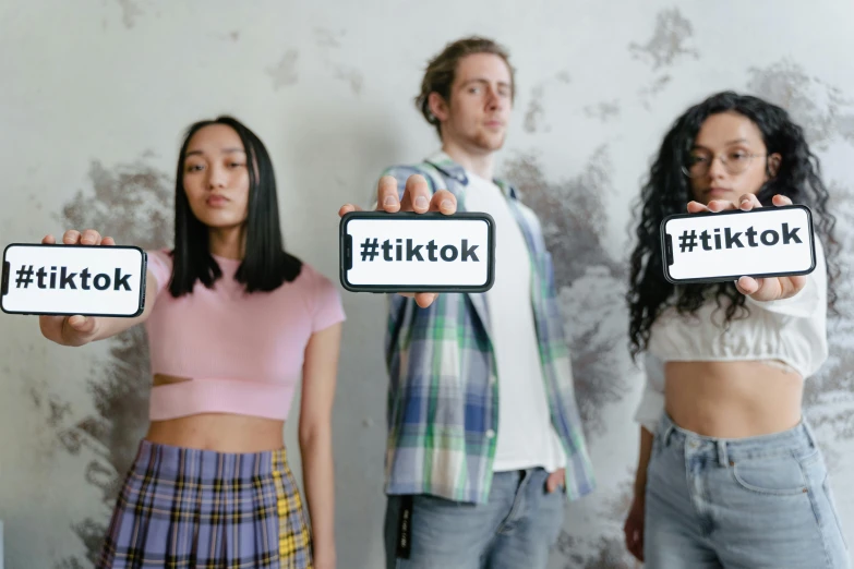 a group of people standing next to each other holding up signs, trending on pexels, tiktok 4 k uhd image, futuristic clothes, wearing a tanktop and skirt, twitter