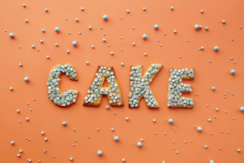 the word cake spelled out of sprinkles on an orange background, inspired by Sarah Lucas, trending on unsplash, photorealism, made out of shiny silver, frank moth, cakes, background image