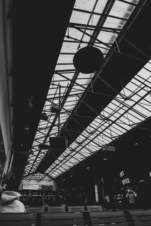 a black and white photo of a train station, by Altichiero, things hanging from ceiling, vsco, ✨🕌🌙, market