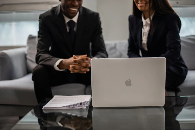 a man and a woman sitting on a couch in front of a laptop, pexels contest winner, lawyer suit, dark-skinned, business meeting, professional image