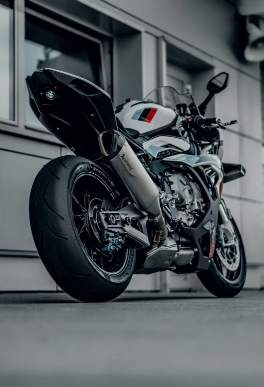 a motorcycle parked in front of a building, by Carlo Martini, pexels contest winner, yoshimura exhaust, on a gray background, bmw, soft rubber