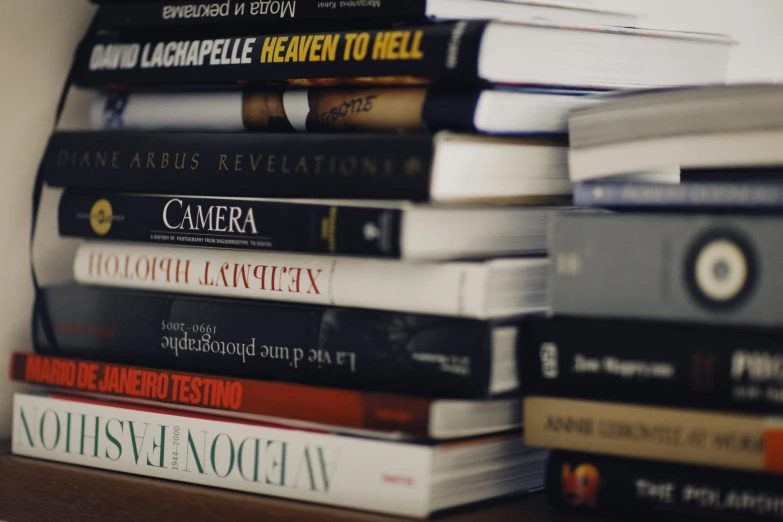 a stack of books sitting on top of a wooden shelf, a picture, by Niko Henrichon, unsplash, academic art, bill henson, religious, on a white table, snapchat photo